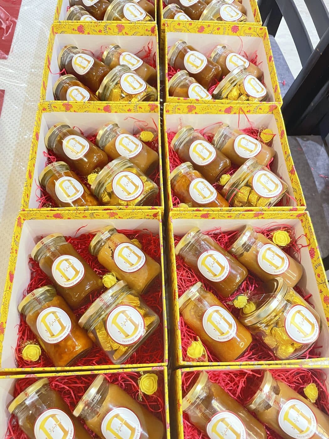 Rows of yellow gift boxes, each packed with jars of Heritage On My Plate chocolates